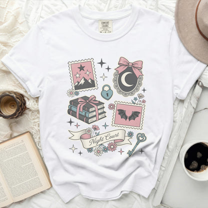 White t-shirt with graphic design of stamps, moon, bats, books, and "Night Court" text.
