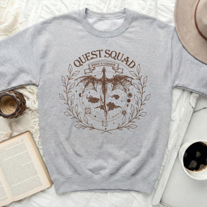 Light gray crewneck sweatshirt with a brown dragon graphic and "QUEST SQUAD RIDOC'S VERSION" text.