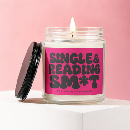 Candle with pink label reading "Single & Reading Sm*t" on a pink background.