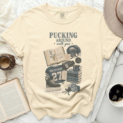Cream t-shirt with "Pucking Around with You" text and hockey book graphics.