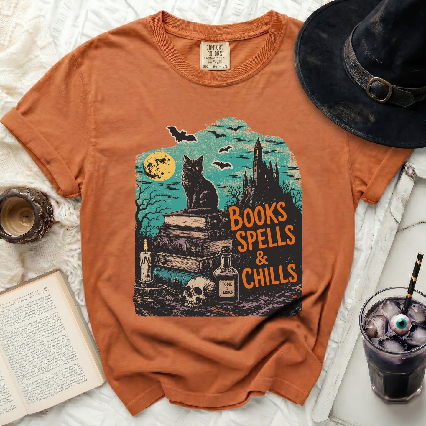 Orange t-shirt with a vintage Halloween graphic of a black cat and castle.