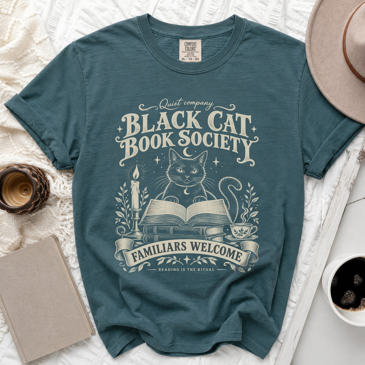 Teal t-shirt with "Black Cat Book Society" text, a cat, books, candle, and tea.