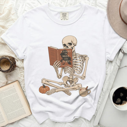 Skeleton reading "A Court of Mist and Fury" book, with pumpkin and latte.