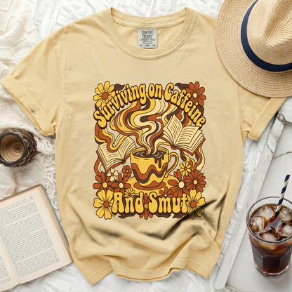 Yellow t-shirt with "Surviving on Caffeine And Smut" graphic.