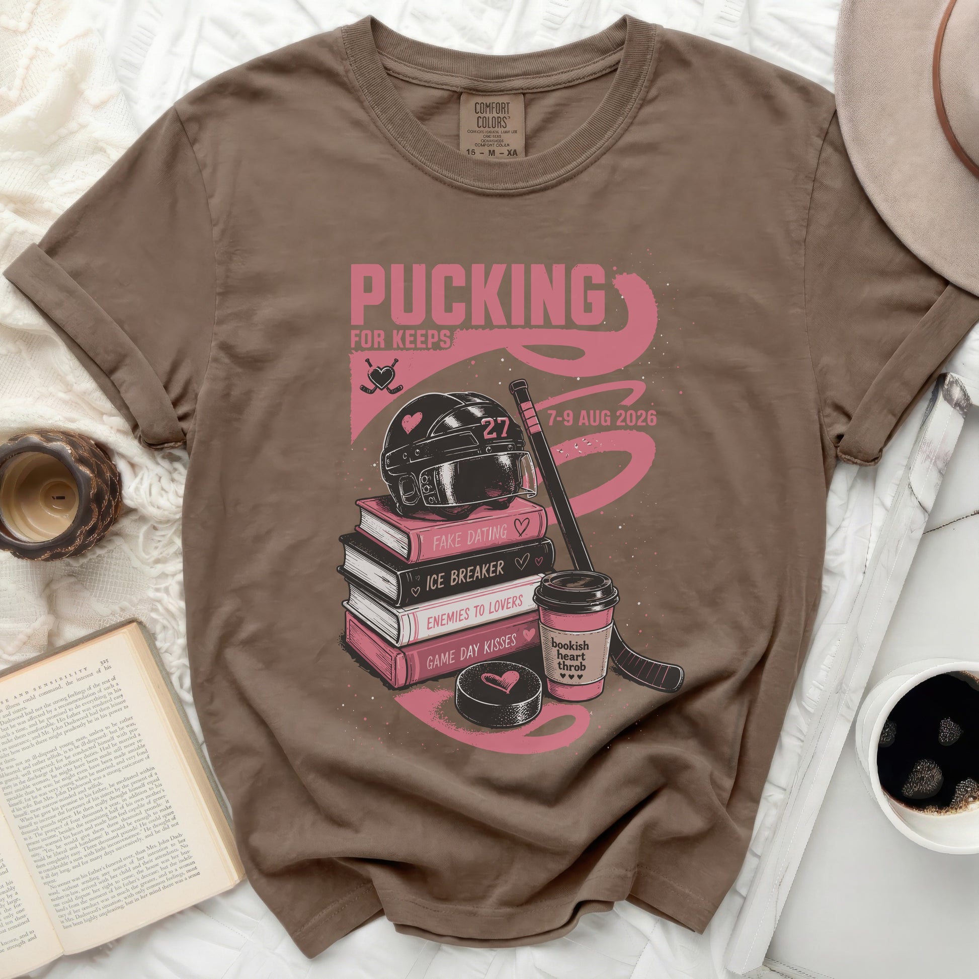Brown t-shirt with "Pucking for Keeps" bookish theme graphics.