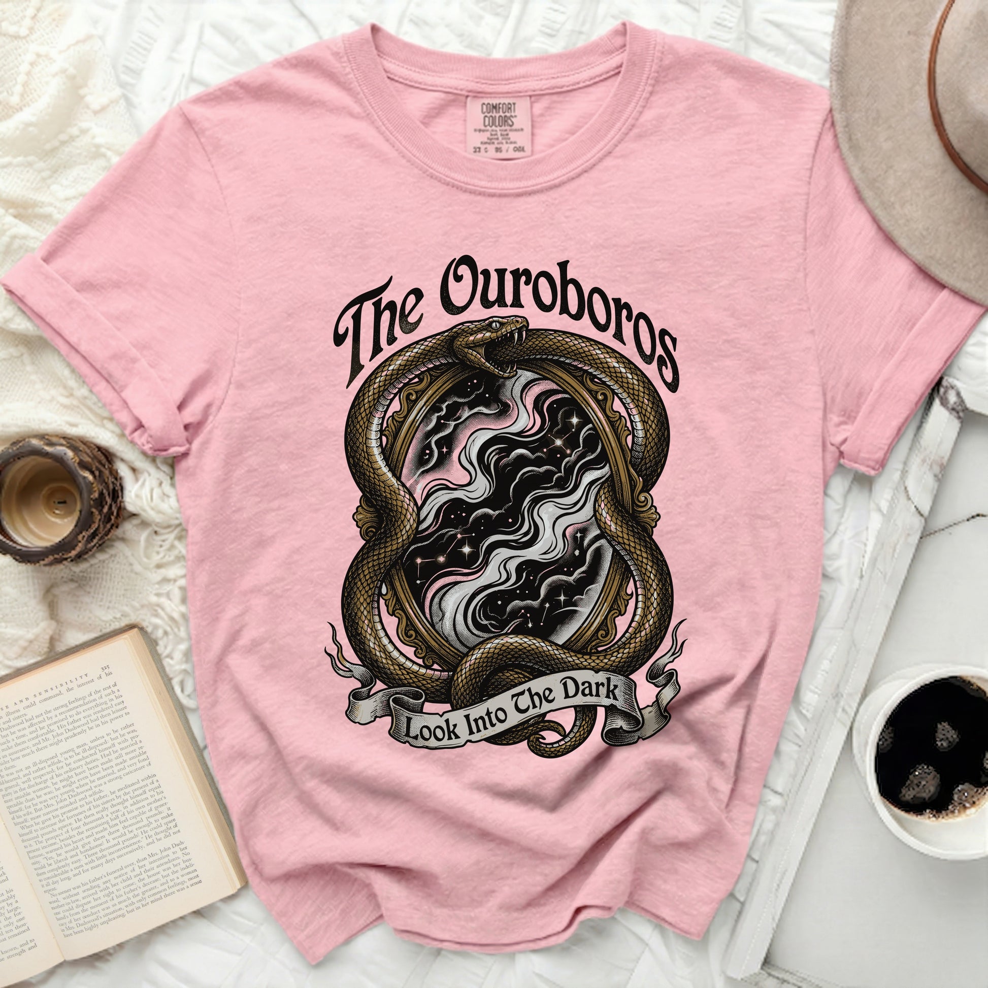 Pink t-shirt with ouroboros snake and "Look Into The Dark" text graphic.
