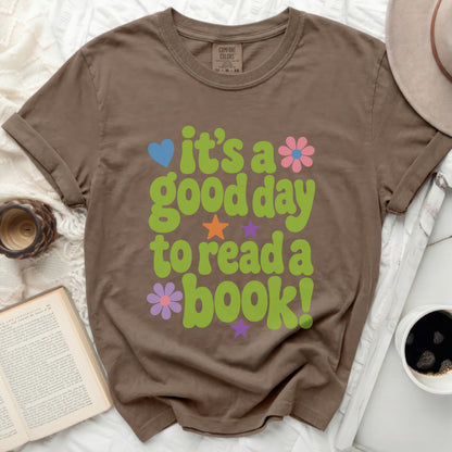 Brown t-shirt with green, pink, and blue "It's a good day to read a book!" graphic.