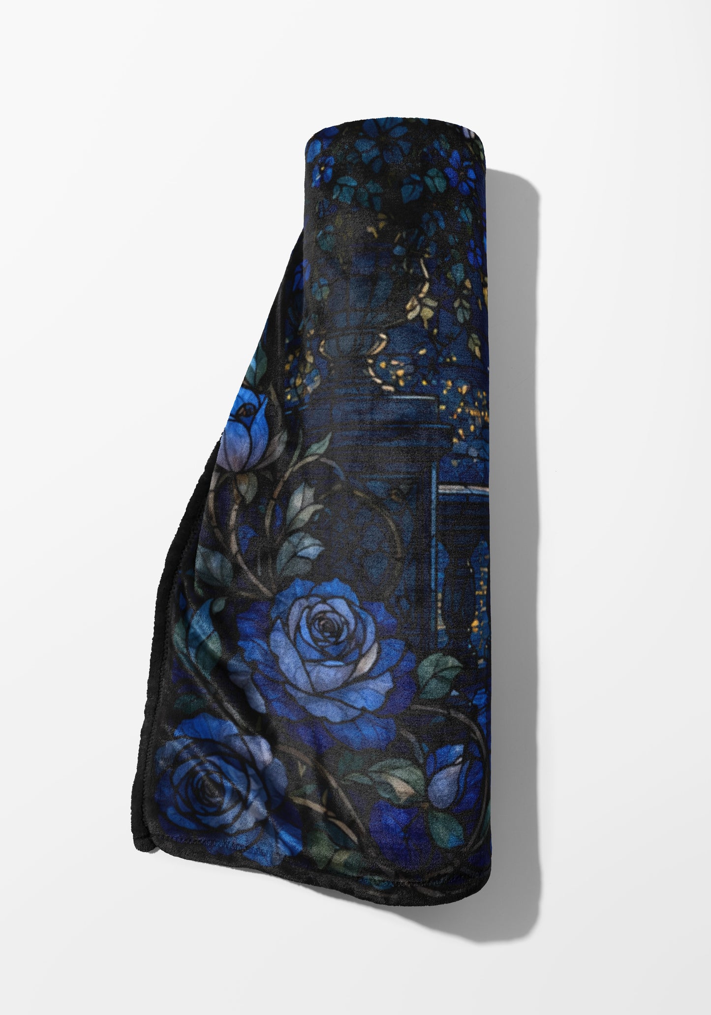 Rolled throw blanket with dark blue roses and thorny vines pattern.