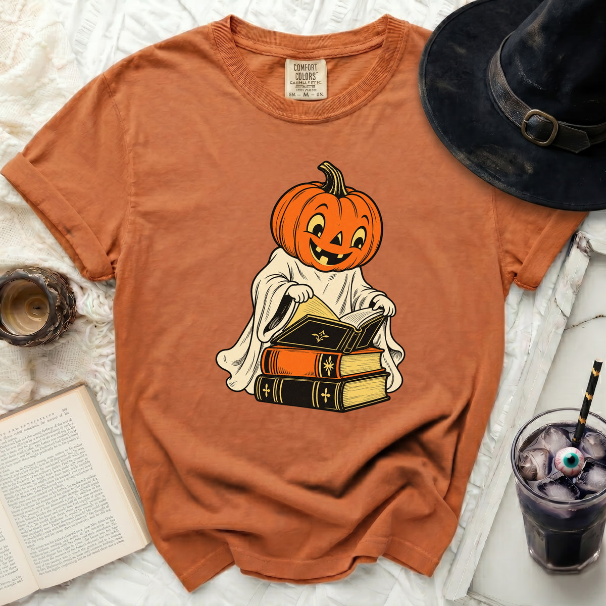 Orange t-shirt with a cartoon pumpkin ghost reading books.