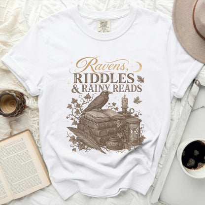 White t-shirt with "Ravens, Riddles & Rainy Reads" graphic.