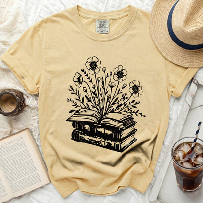 Yellow t-shirt with black graphic of open books and flowers.