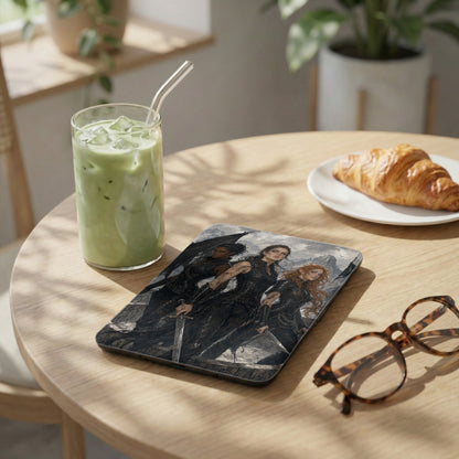 Tablet cover with three fantasy women holding swords, next to a matcha drink and croissant.