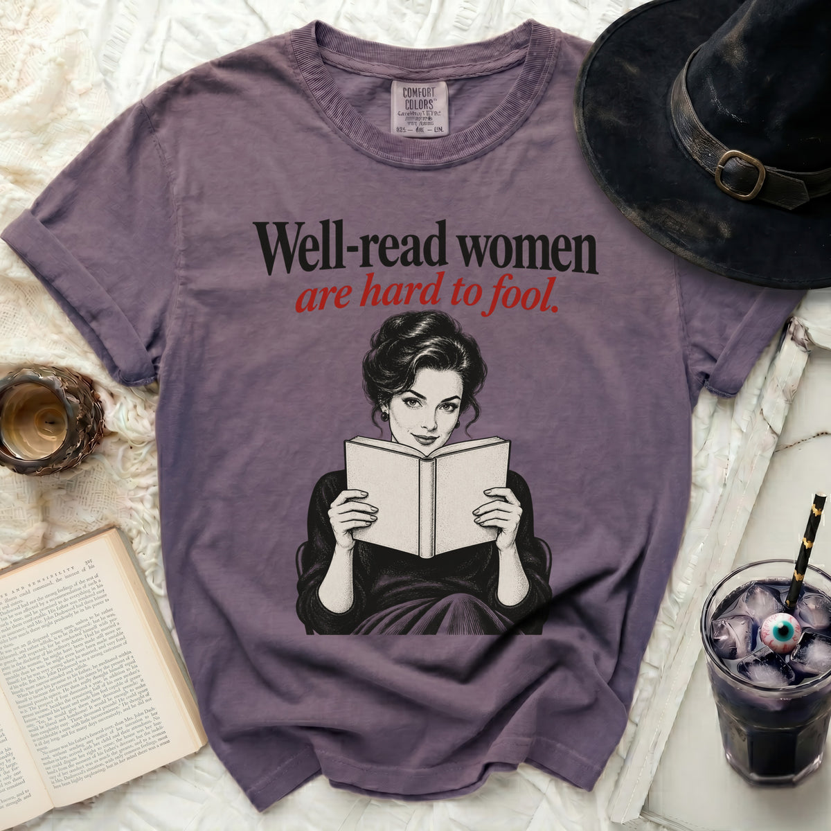 Purple t-shirt with "Well-read women are hard to fool" and vintage woman reading.