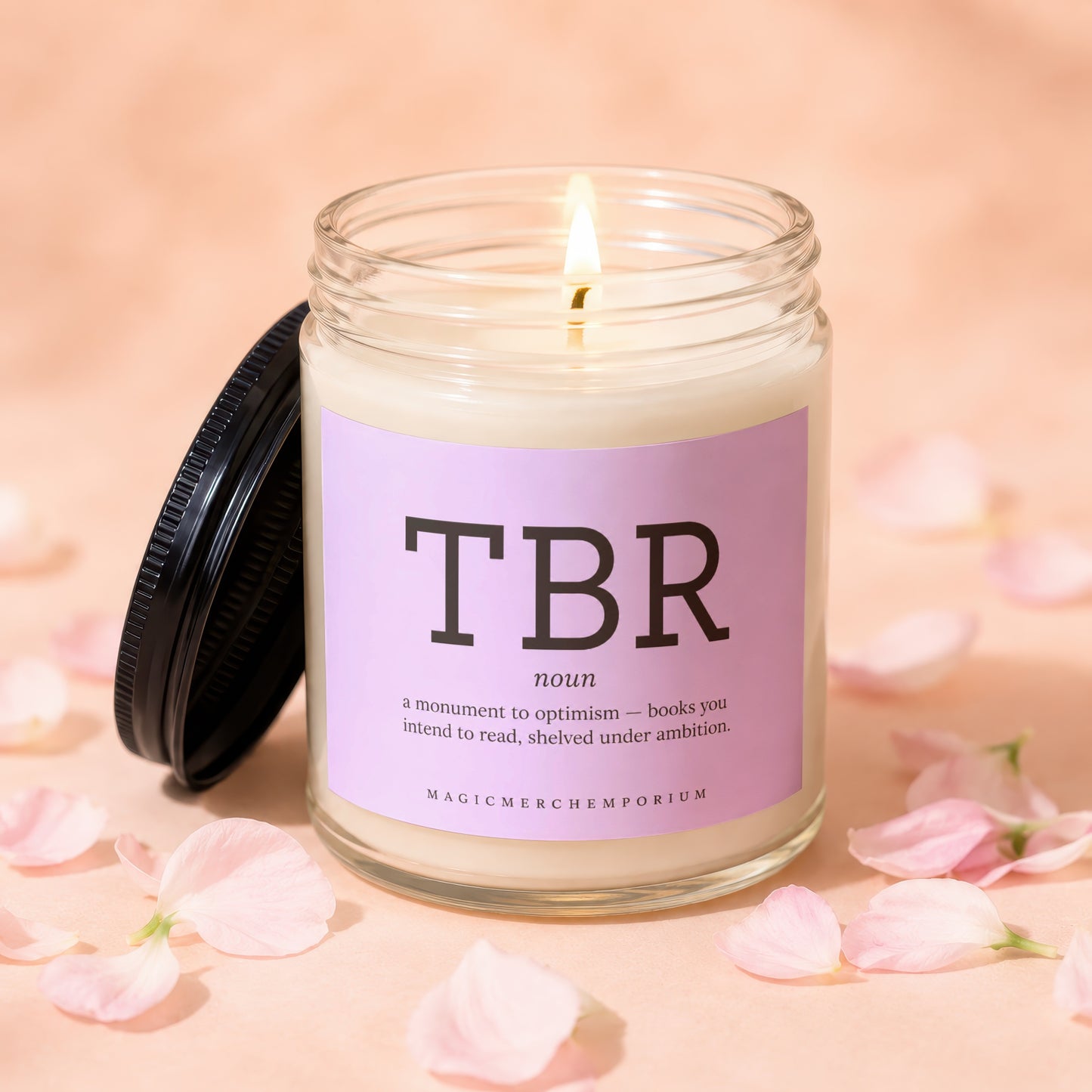 Lit candle in glass jar with pink label reading "TBR" and "MAGICMERCHEMPORIUM".