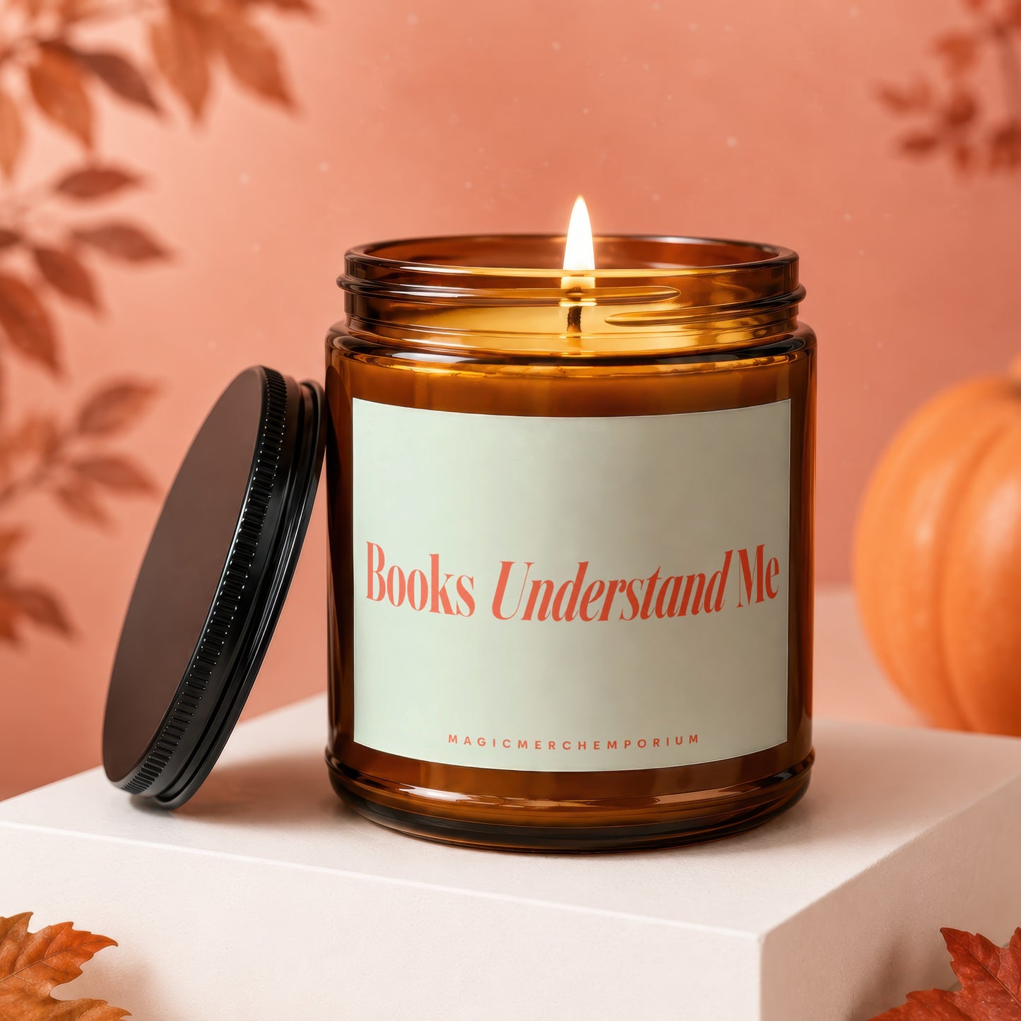 Lit amber candle with label "Books Understand Me" and "MAGICMERCH}|EMPORIUM"