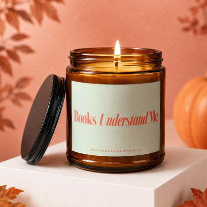 Lit amber candle with label "Books Understand Me" and "MAGICMERCH}|EMPORIUM"