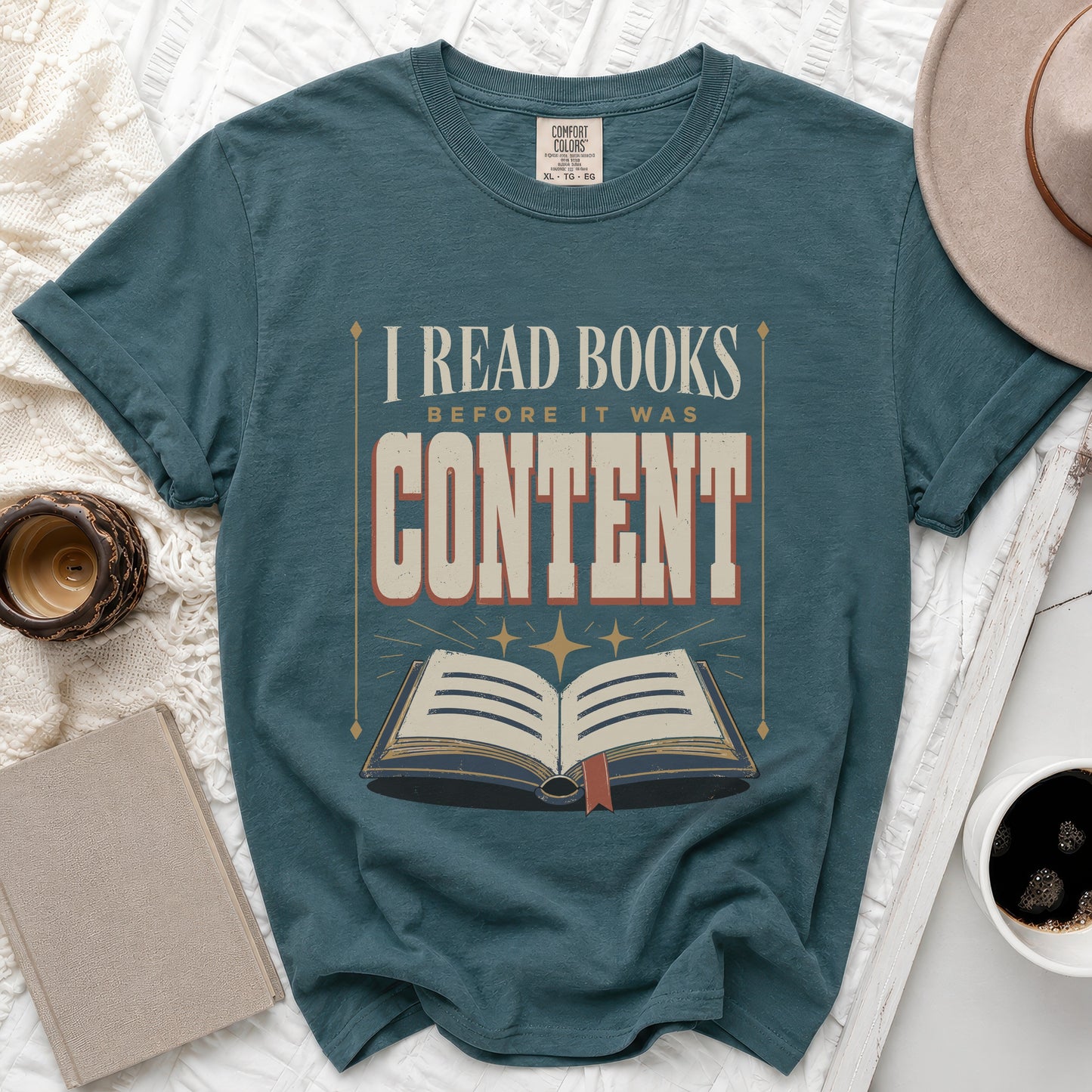 Teal t-shirt with "I READ BOOKS BEFORE IT WAS CONTENT" text and an open book graphic.
