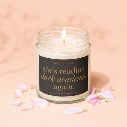 Lit candle in a glass jar with text "she's reading dark academia again."