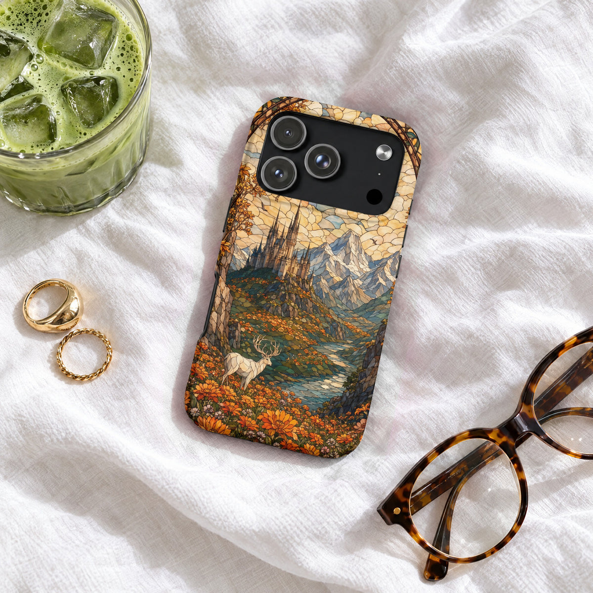 Stained glass style landscape phone case featuring a castle, mountains, and a deer on white fabric.