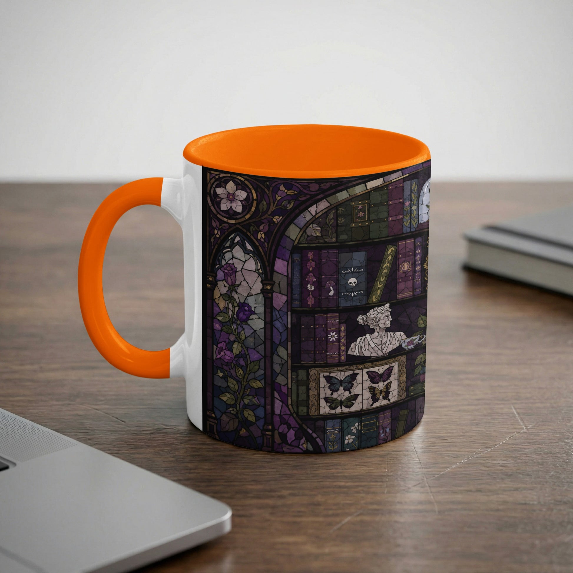 White mug with orange handle, featuring a stained glass design of a bookshelf.