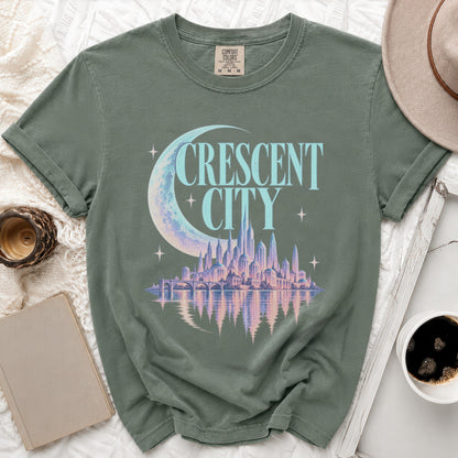 Green t-shirt with "Crescent City" text and a pastel city skyline graphic.