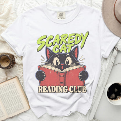 White t-shirt with a cartoon black cat reading a book, "Scaredy Cat Reading Club" text.