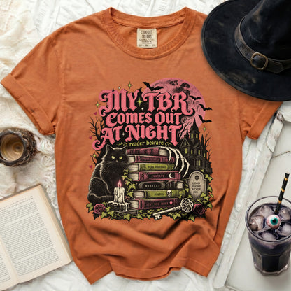 Orange t-shirt with "My TBR Comes Out At Night" Halloween-themed graphic.