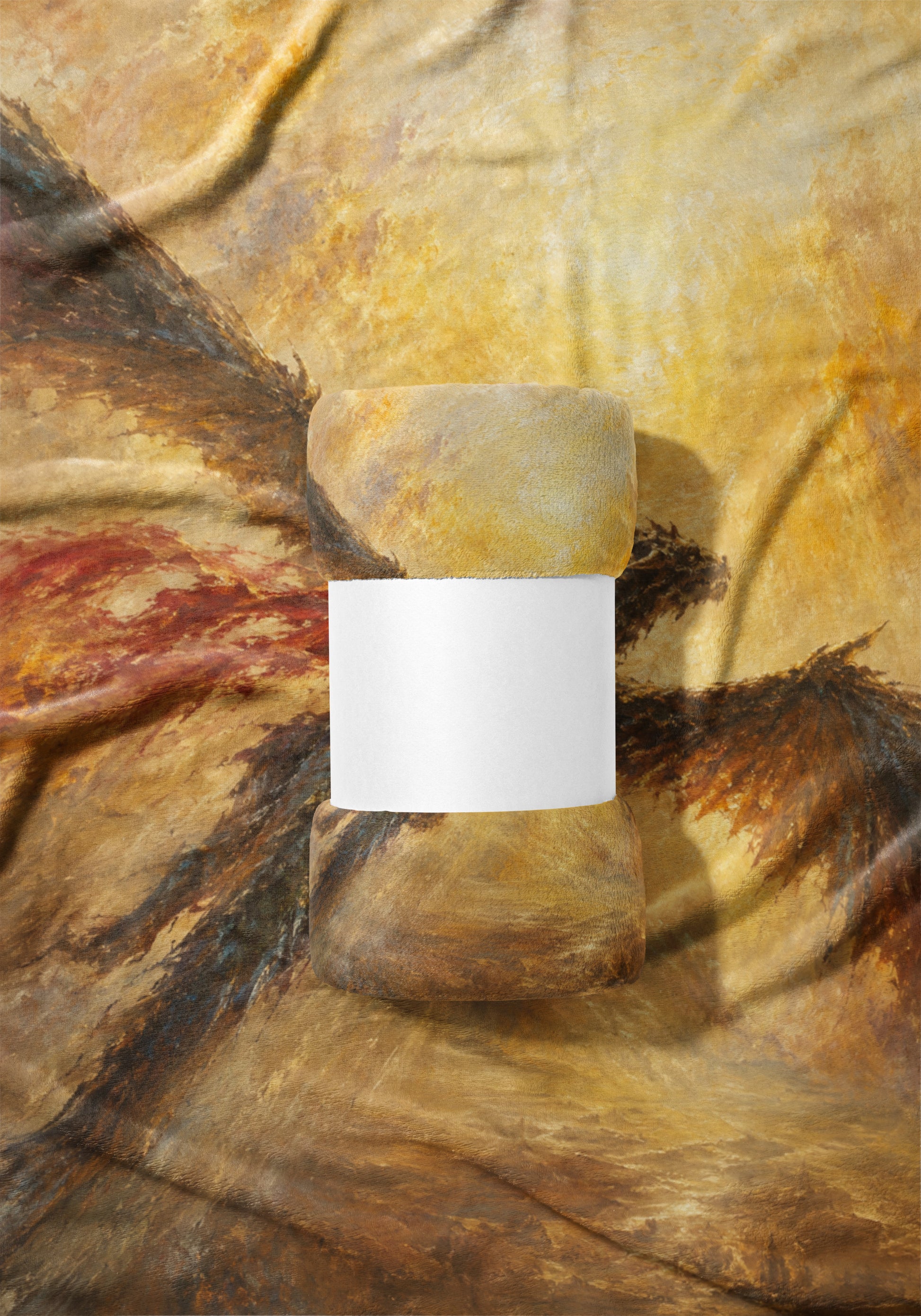 Two textured cylindrical objects sit on a fabric with a painterly, abstract design.