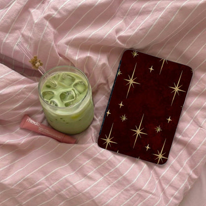 Phone accessory with star pattern rests beside iced matcha drink and lip balm.