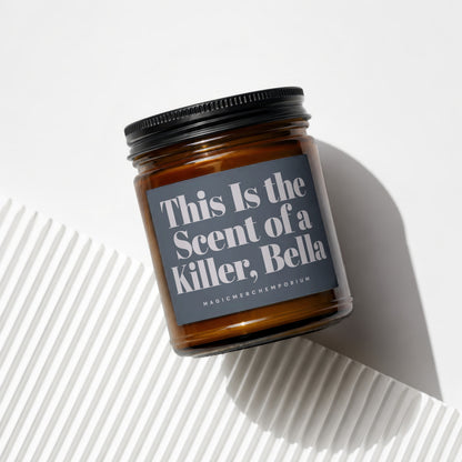 Amber glass candle with dark gray label reading "This Is the Scent of a Killer, Bella".
