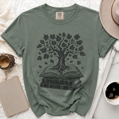 Green t-shirt with black tree of knowledge growing from stacked books graphic.