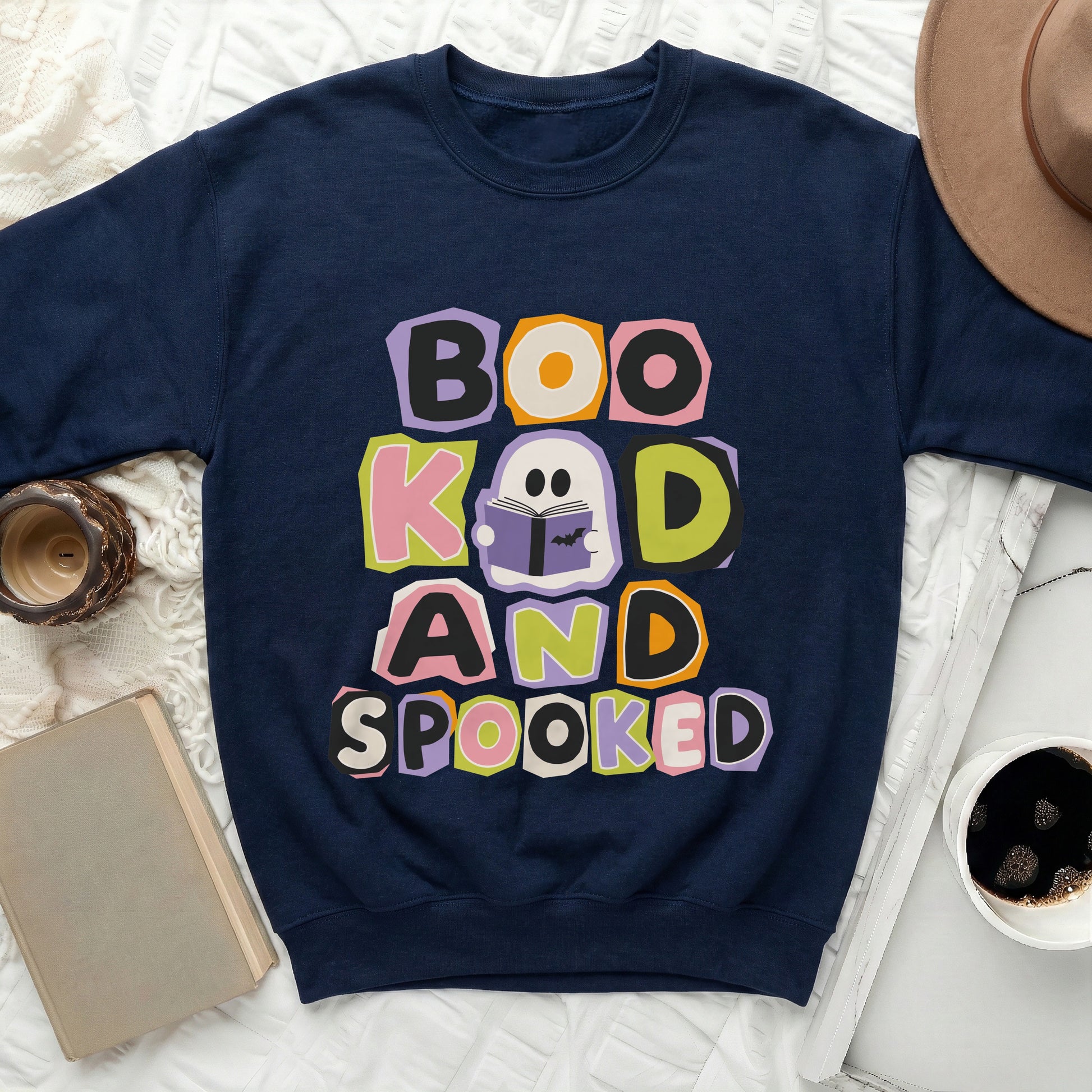 Navy sweatshirt with colorful "Boo Kad and Spooked" ghost reading book graphic.