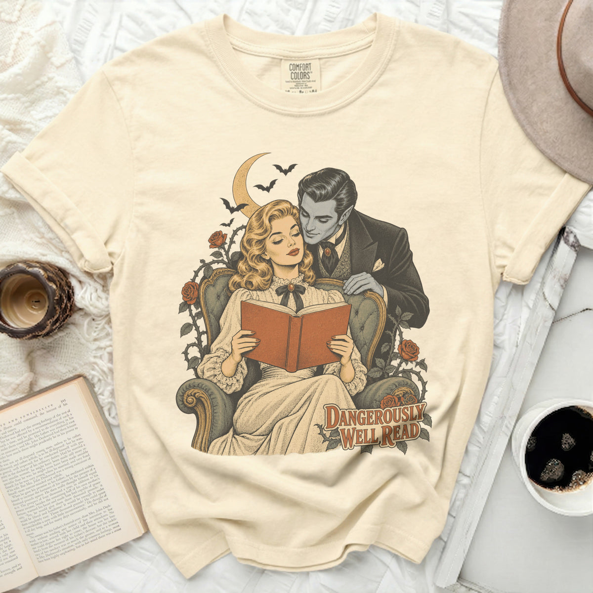 T-shirt with graphic of a vampire leaning over a woman reading, text "DANGEROUSLY WELL READ".