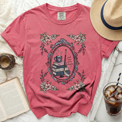 Pink t-shirt with "Just One More Puck Love Story" hockey and book graphic.