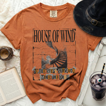 Orange t-shirt with "HOUSE OF WIND" and "10,000 STEPS SURVIVOR MIND THE DROP" text.