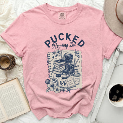 Pink t-shirt with "Pucked Reading List" and hockey gear illustration.