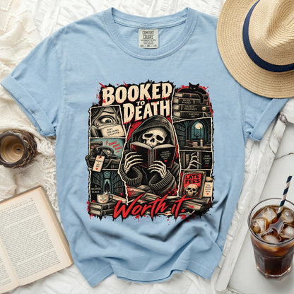 Light blue t-shirt with "Booked to Death Worth It" graphic of a skeleton reading.