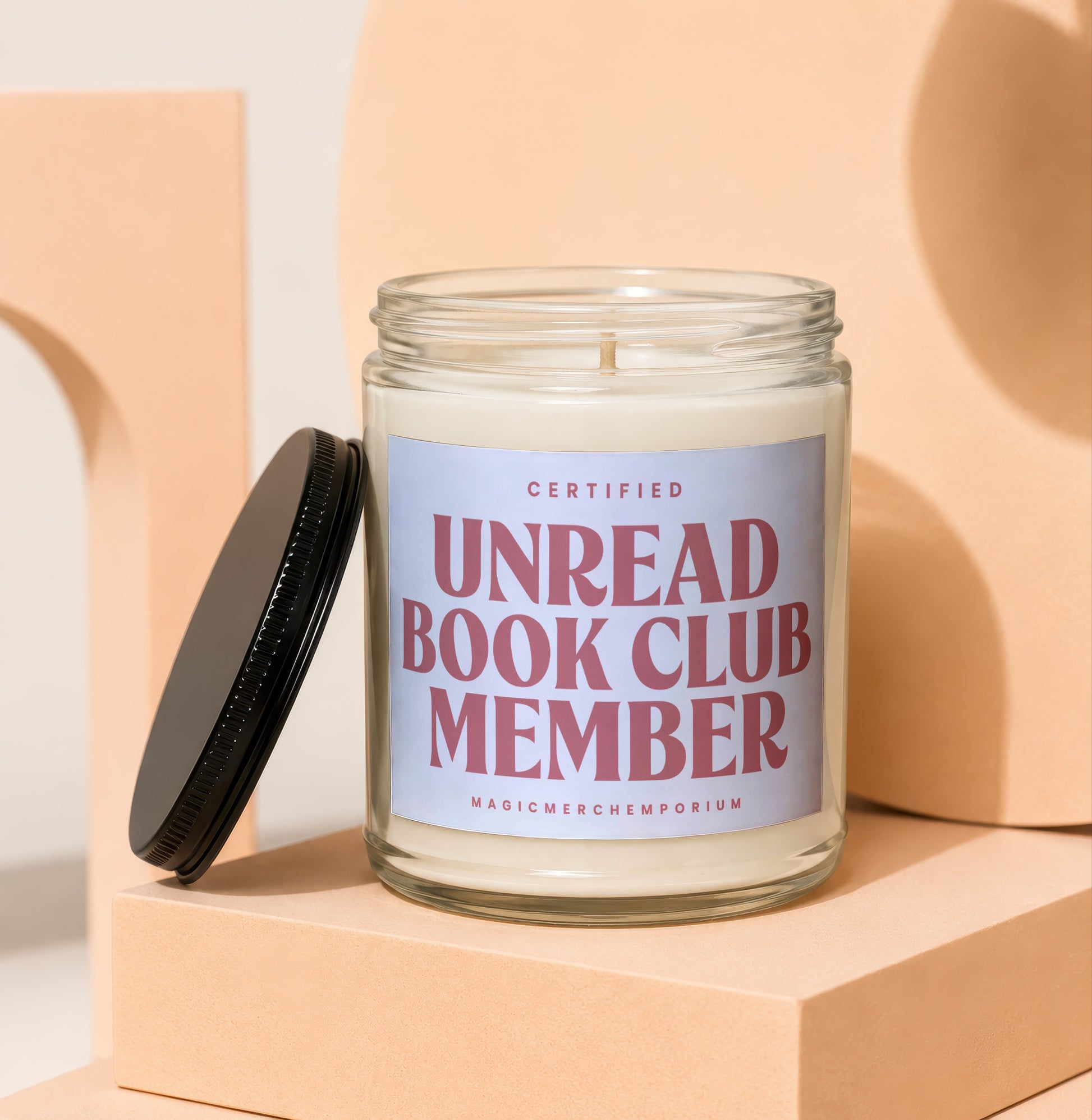 Candle with text "CERTIFIED UNREAD BOOK CLUB MEMBER" and "MAGICMERCHEMPLORIUM".