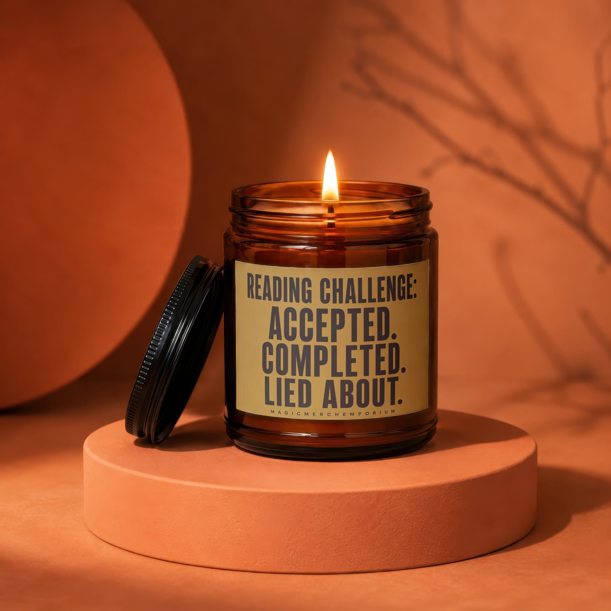 Amber jar candle with lid off, lit flame, reading challenge text, MagicMerchEmporium logo.