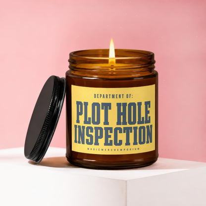 Amber jar candle with lit flame, lid off, and yellow label reading "Department of: Plot Hole Inspection".