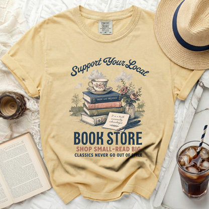 Yellow t-shirt with "Support Your Local Book Store" graphic featuring books and tea.
