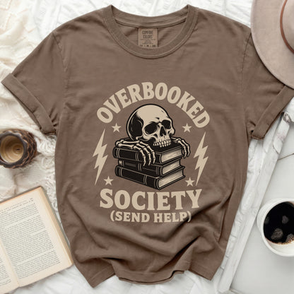 Brown t-shirt with a skeleton reading books and "Overbooked Society (Send Help)" graphic.