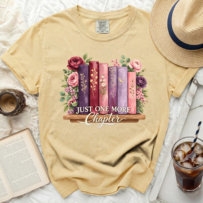 Yellow t-shirt with books, flowers, and text "JUST ONE MORE Chapter".