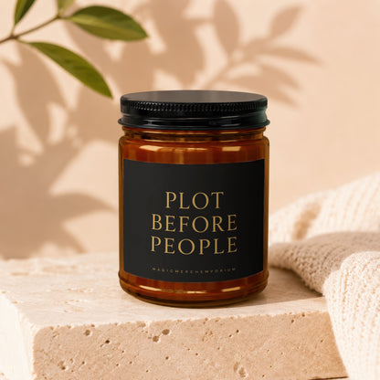 Amber jar candle with black label reading "PLOT BEFORE PEOPLE MAGICMERCH.COM"