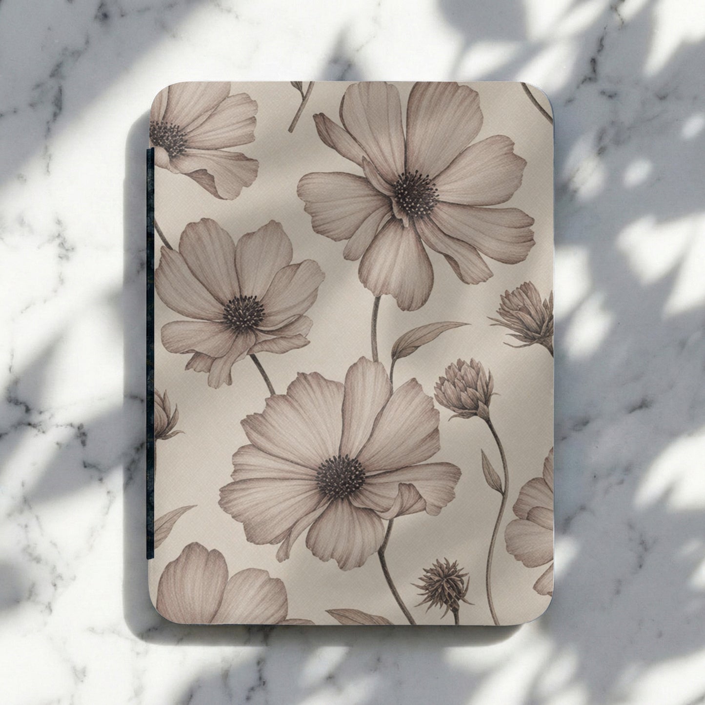 Notebook with sepia watercolor floral pattern on a marble surface.