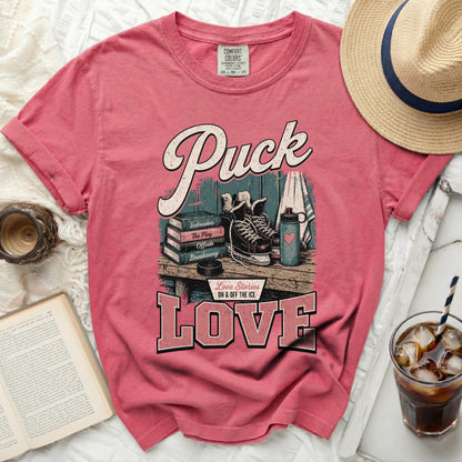 Pink t-shirt with "Puck Love" and hockey-themed graphics.