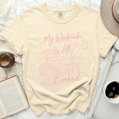 Cream t-shirt with "My Weekend Is All Booked" beach graphic.