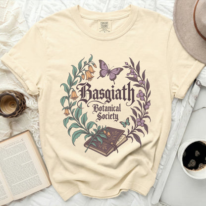 Light yellow t-shirt with "Basgiath Botanical Society" text and floral design.