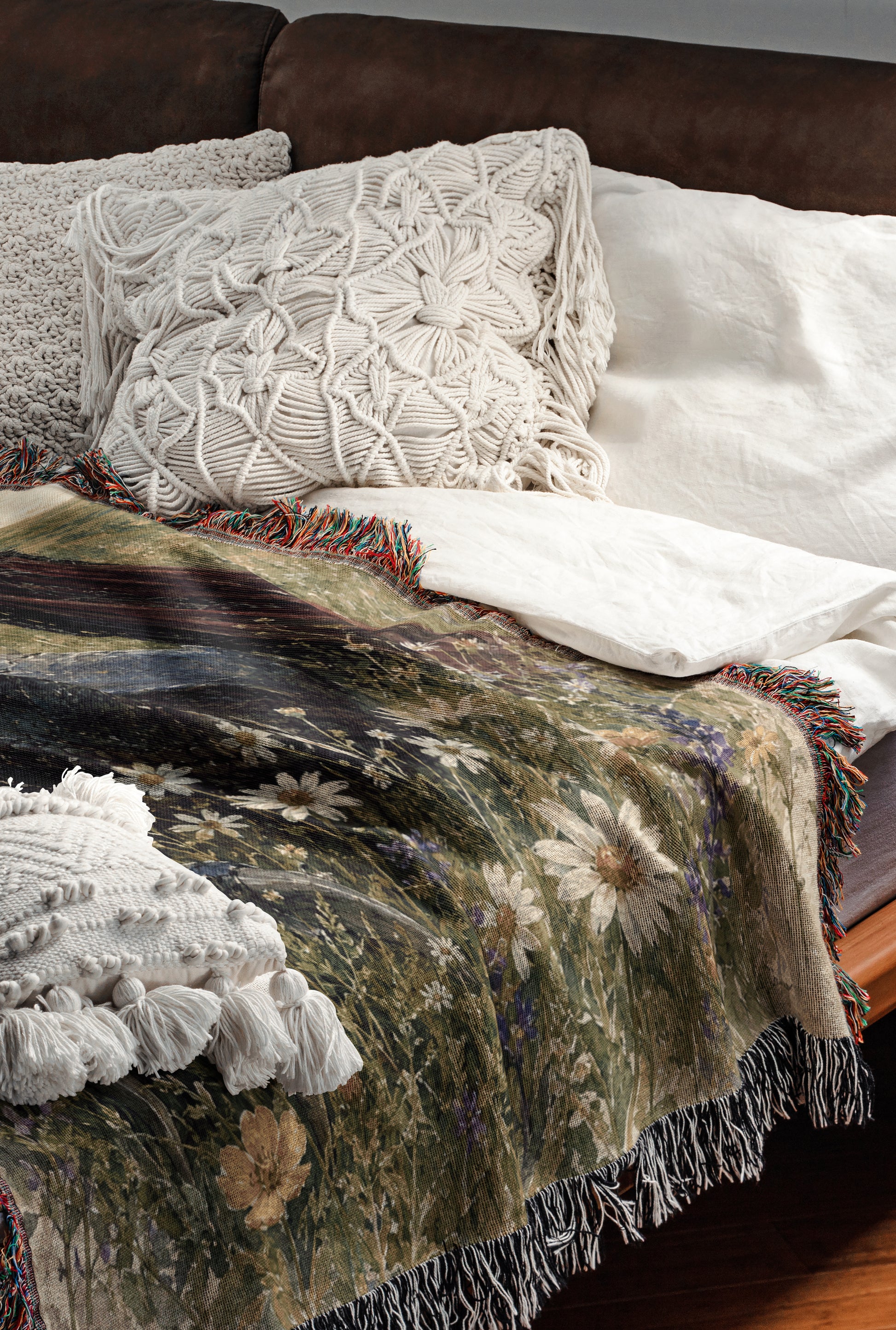 a cozy and inviting bedroom scene, featuring a bed with a floral-patterned blanket and a white pillow. The bed is set against a brown leather headboard, creating a warm and comfortable atmosphere.