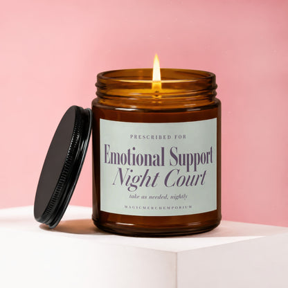 Amber jar candle with lit wick and black lid, reads "Emotional Support Night Court".